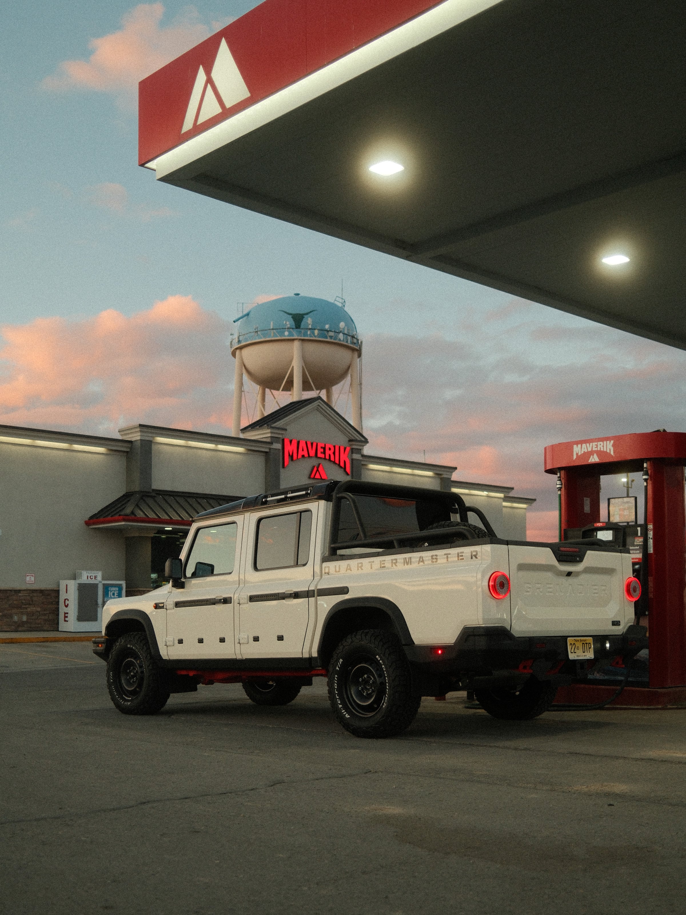 An INEOS Grenadier Quartermaster at a Maverik gas station at dusk