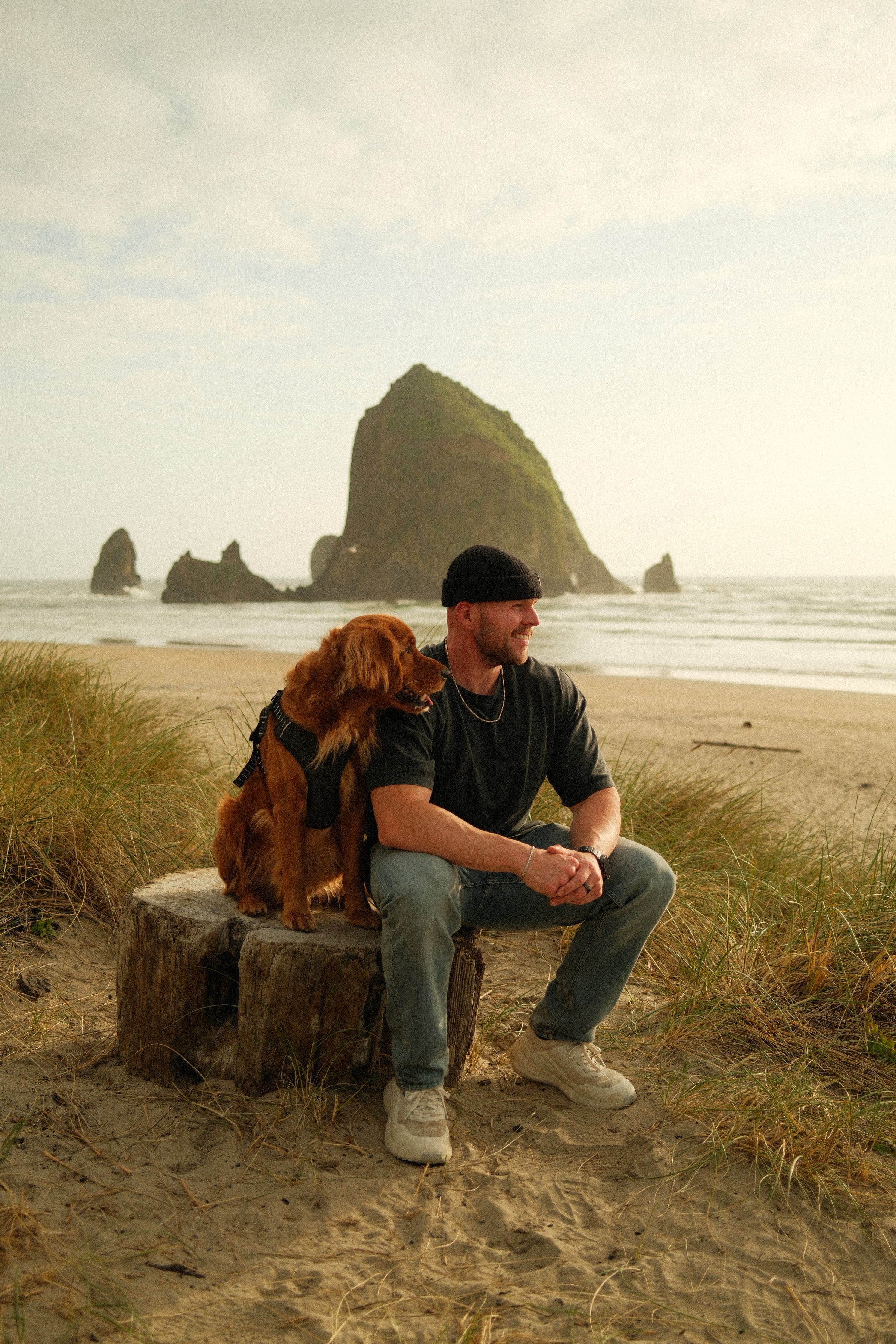 Max Loew and his golden retriever on the beach at Haystack Rock, Oregon