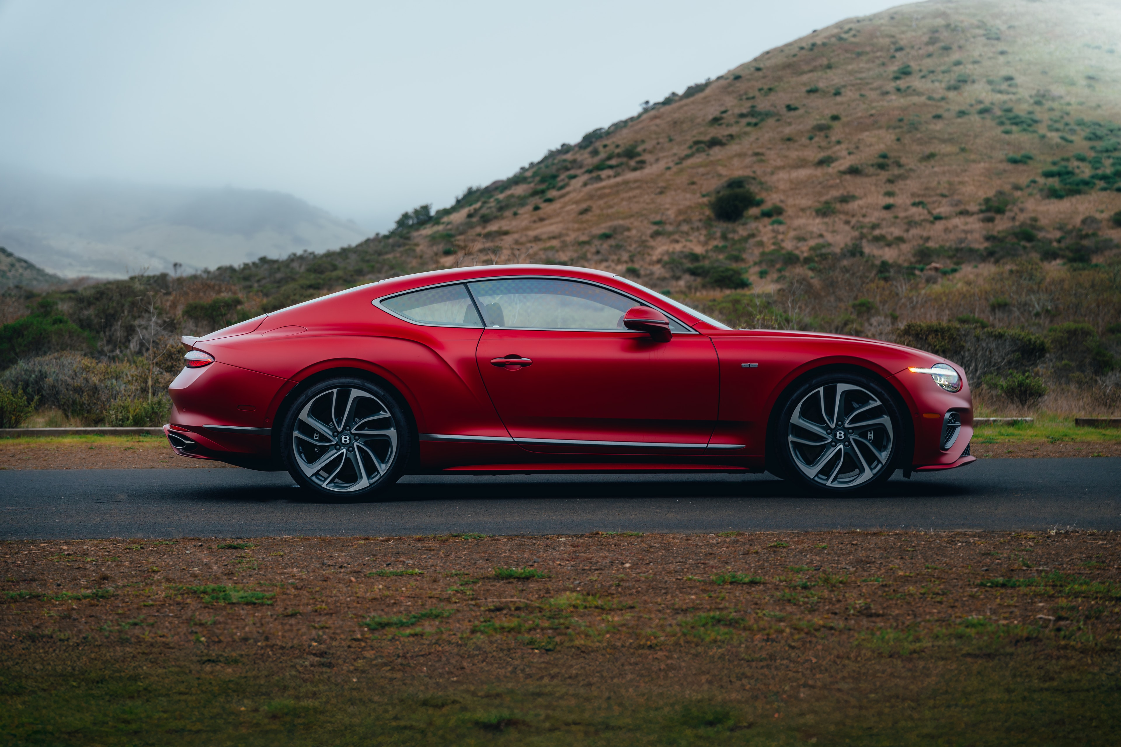 Continental GT side profile against fog-soft California hills