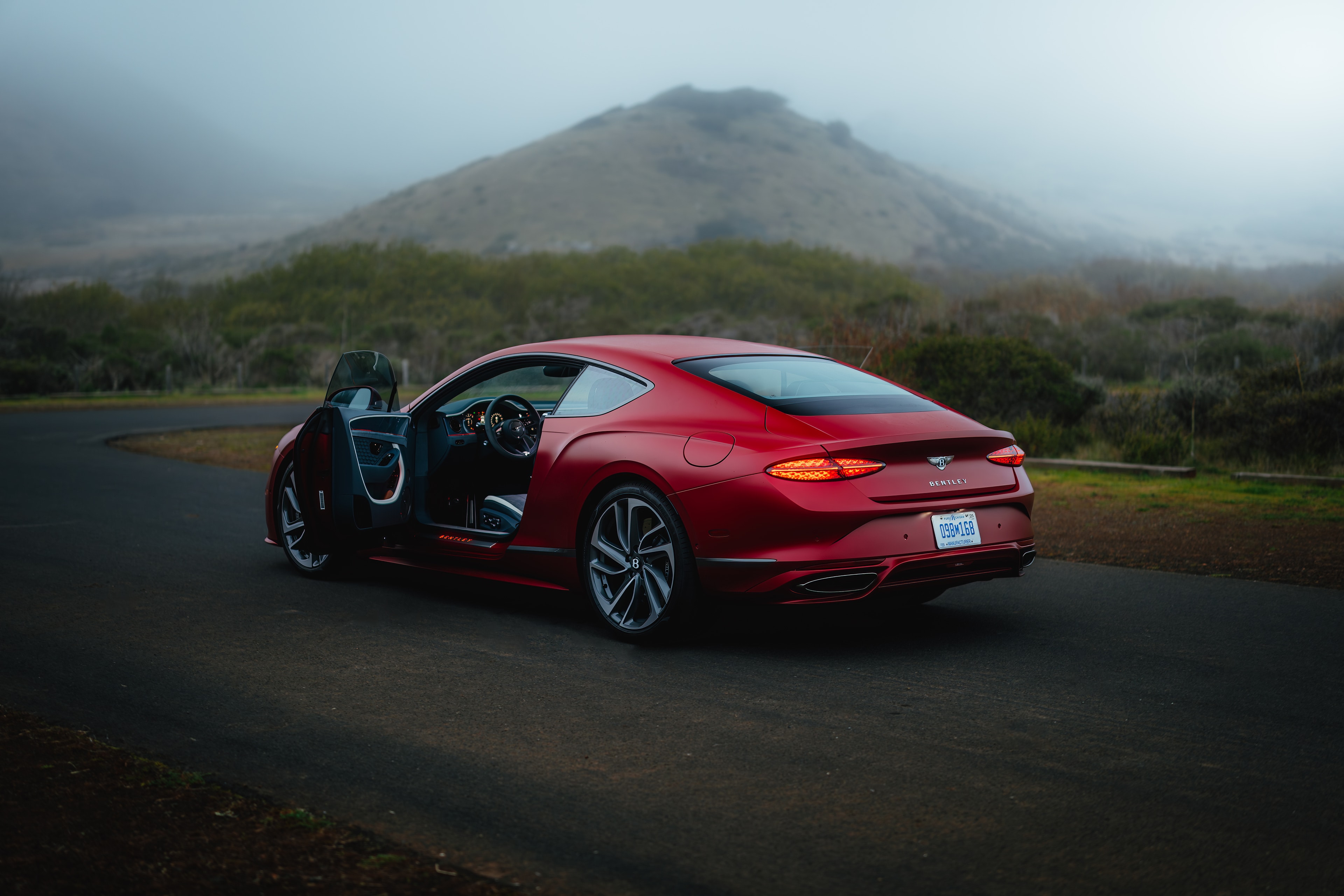 Continental GT on a hilltop road, driver's door open