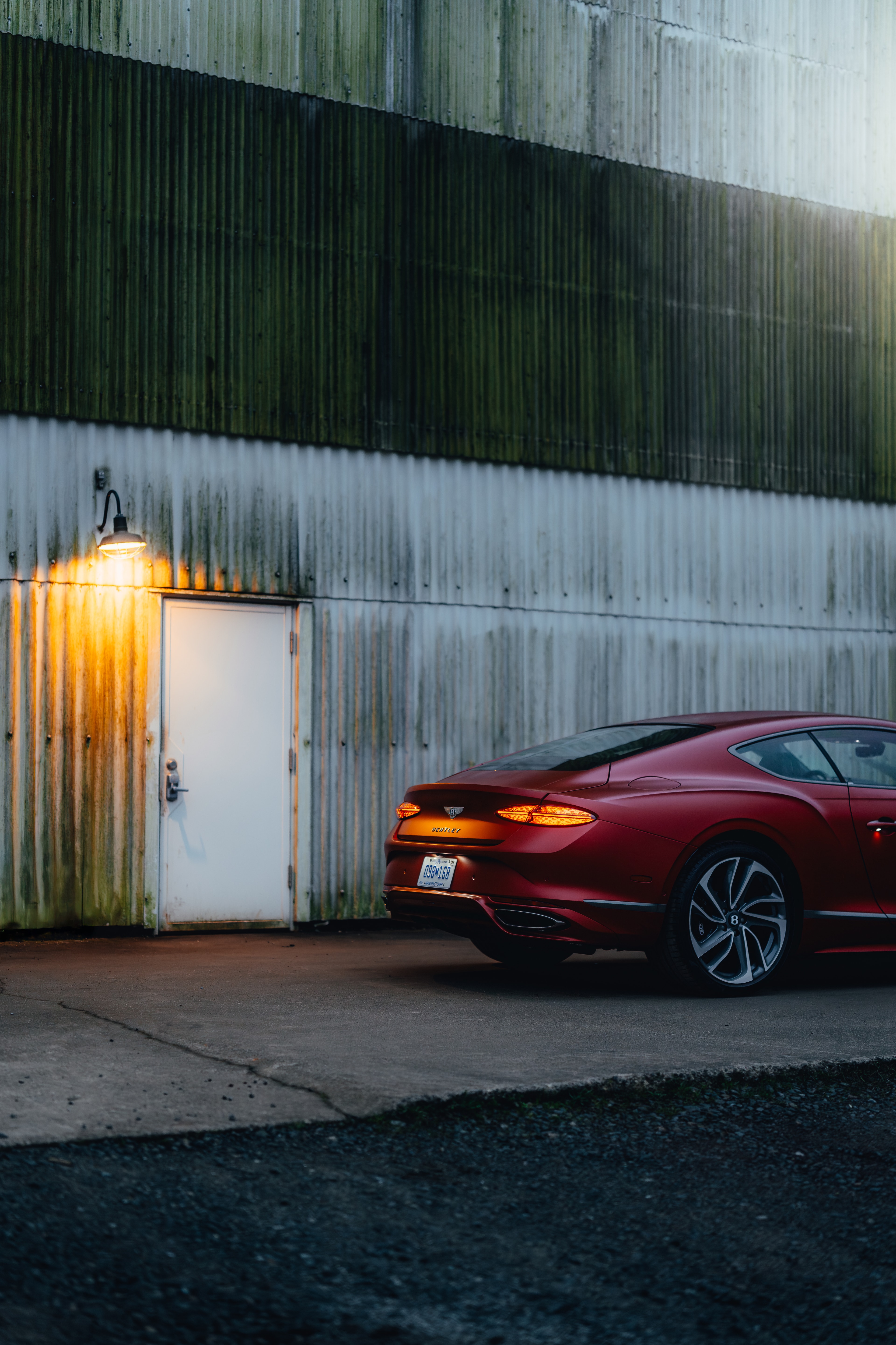 Continental GT rear at industrial location, warm door light