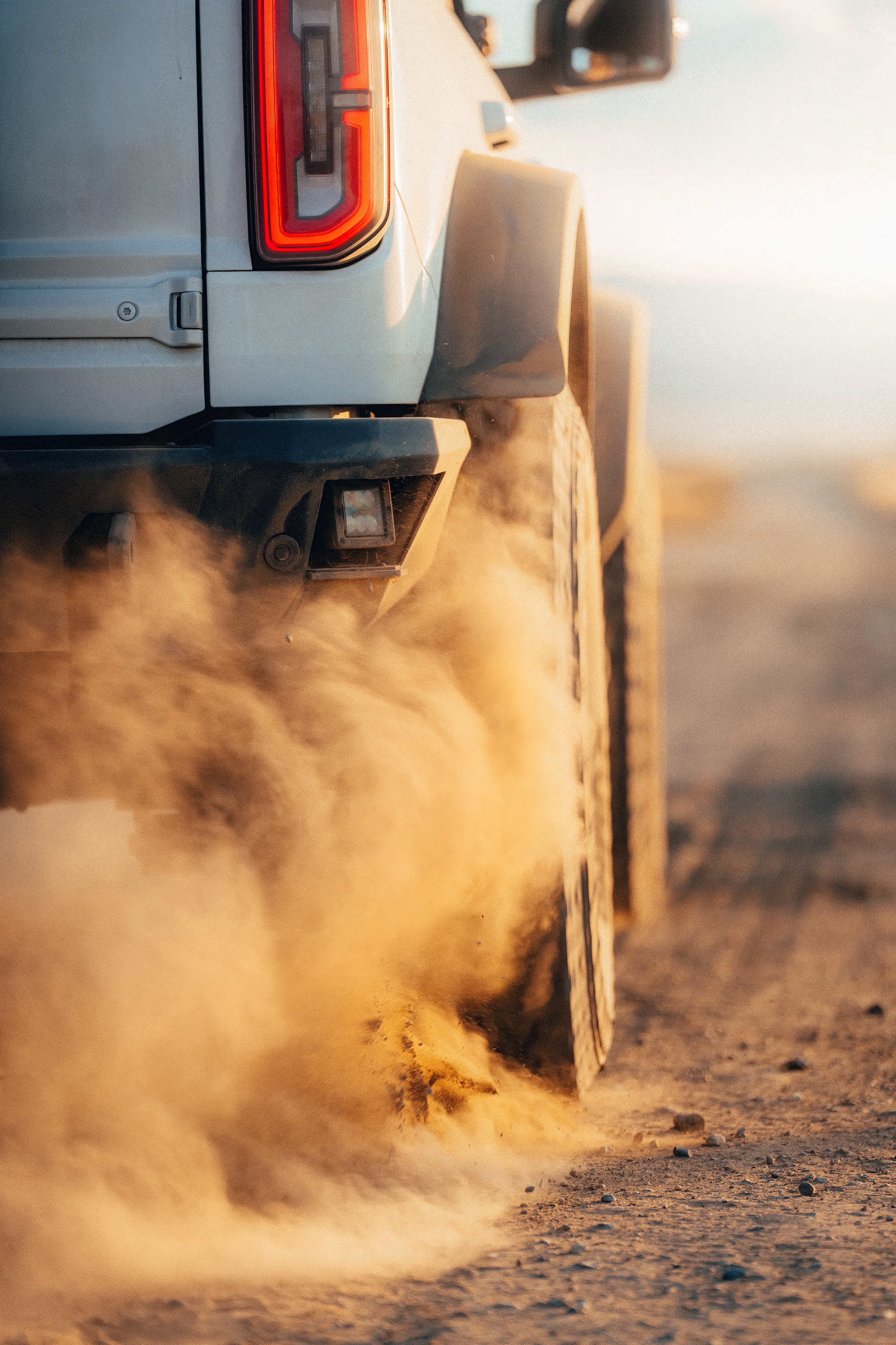 Ford Bronco rear tail-light with dust kicking up off the tires