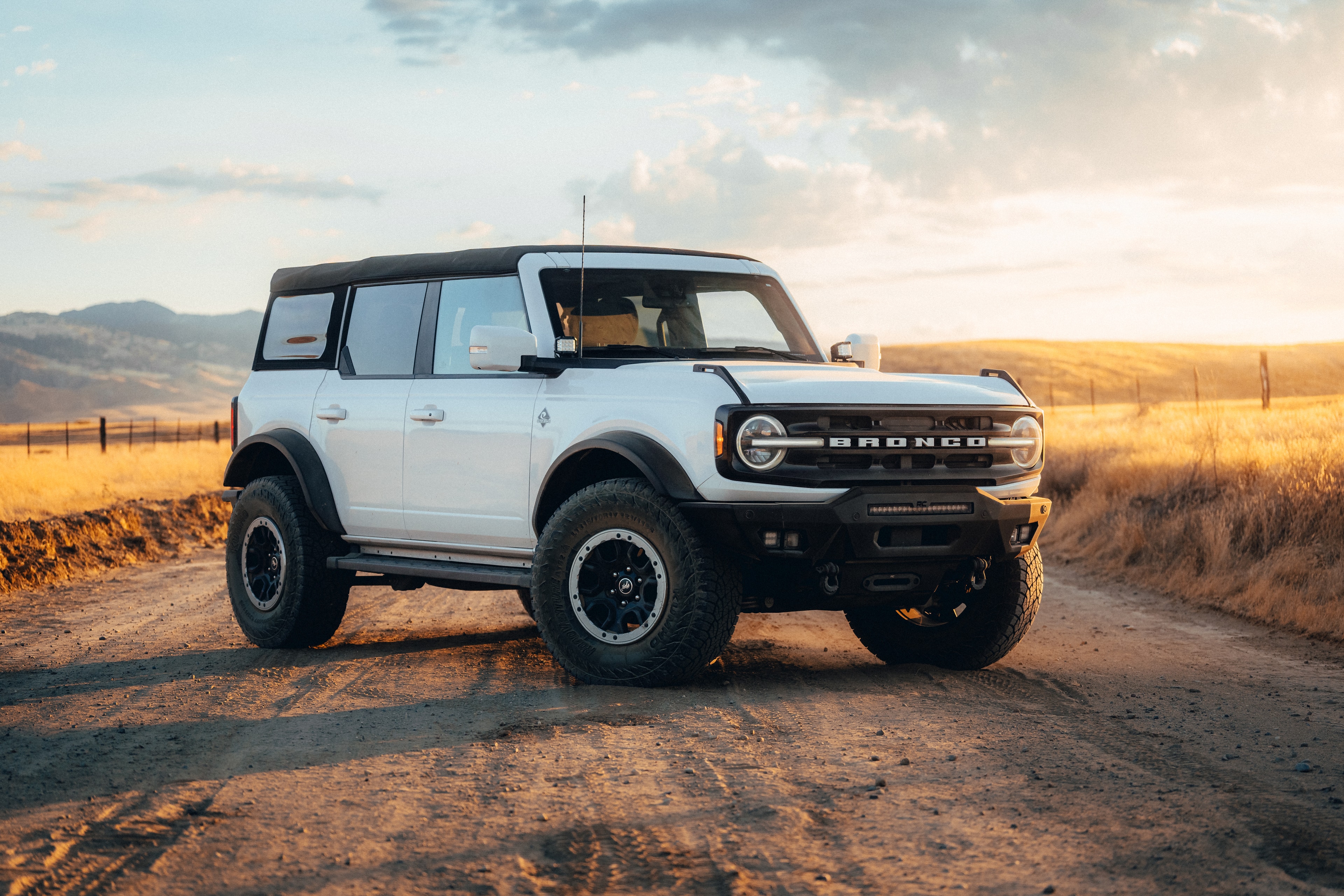 Ford Bronco at golden hour on a dirt road, three-quarter beauty shot