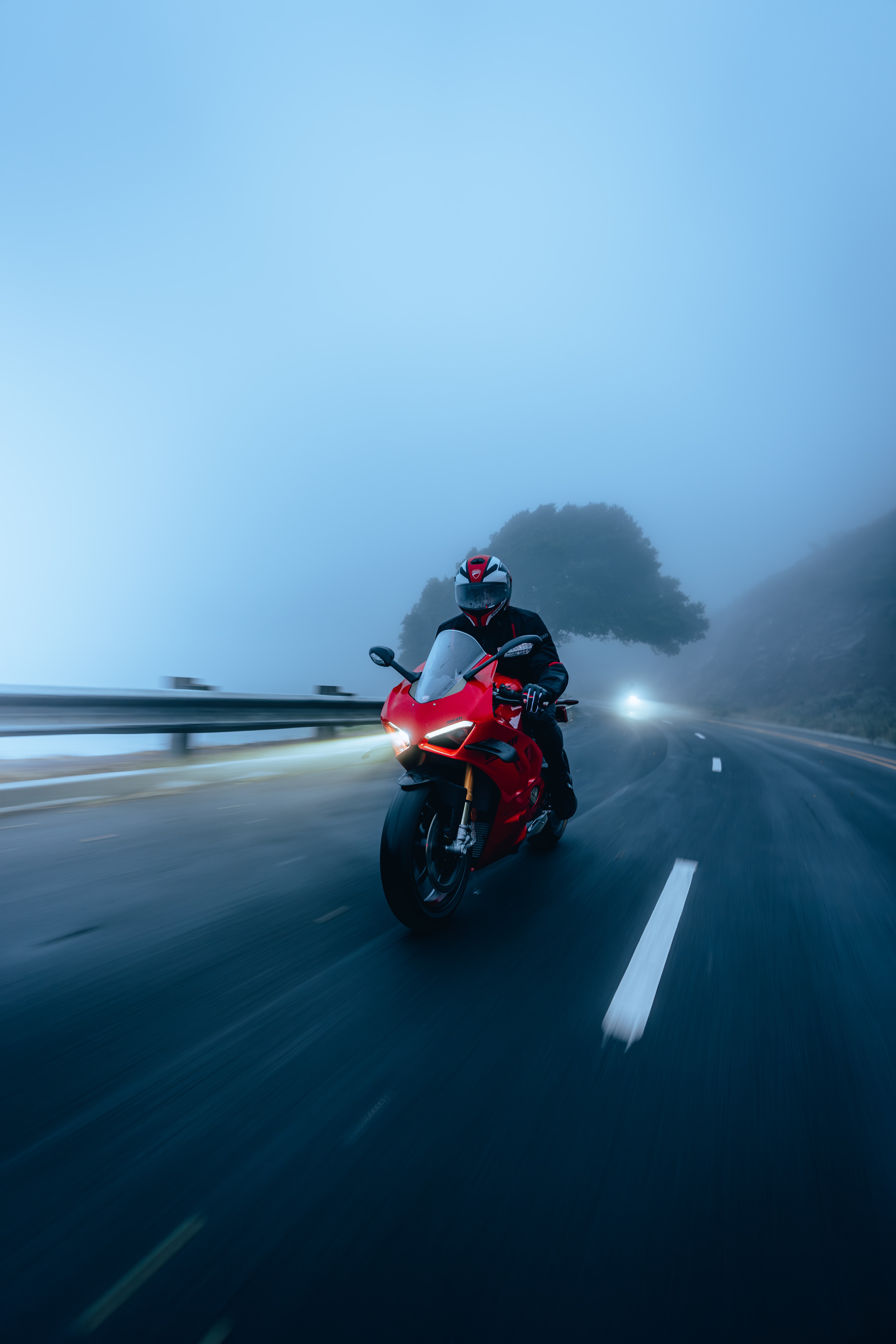 Ducati Panigale V4S rider in coastal fog at speed, motion blur