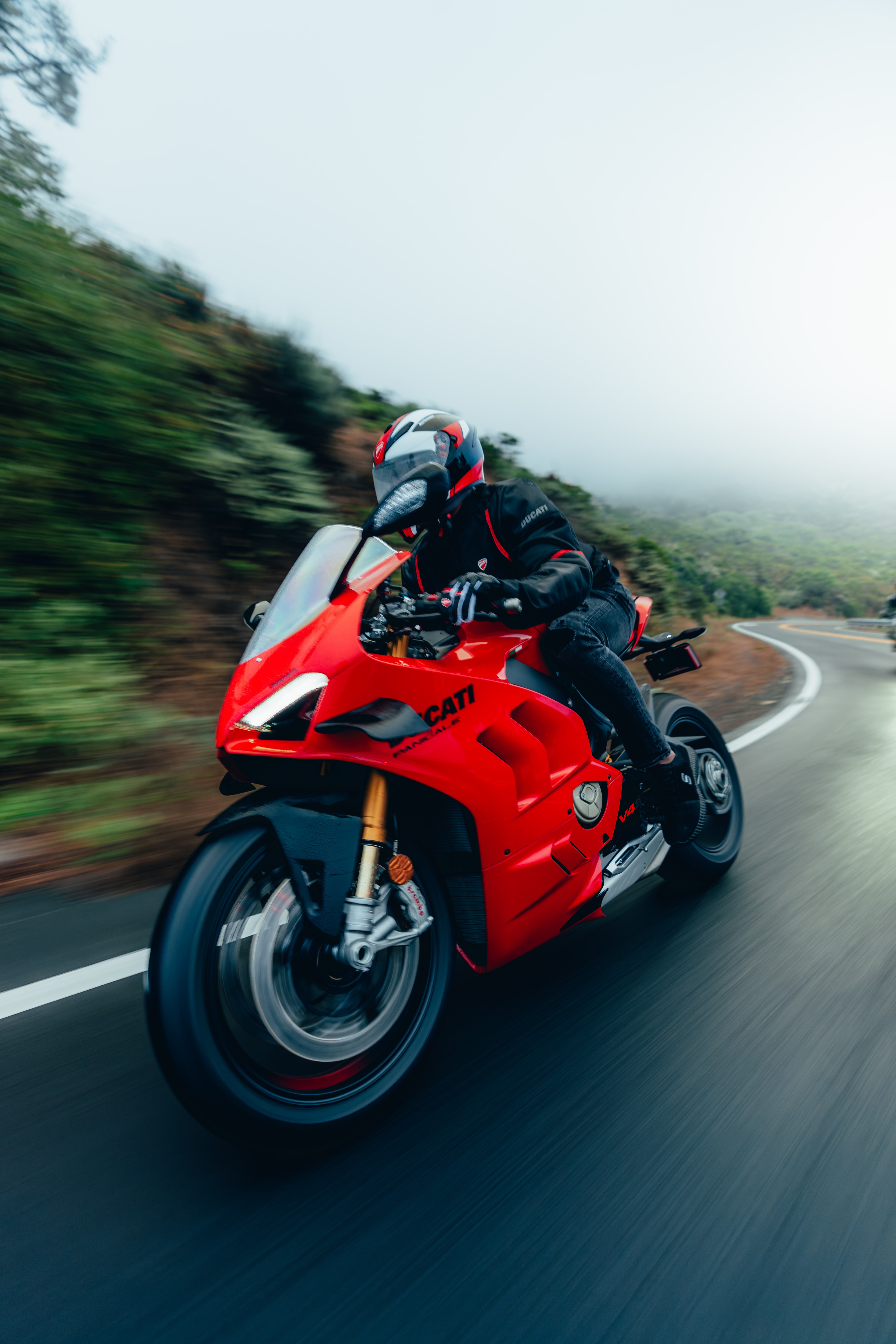 Ducati Panigale V4S leaning into a coastal curve, motion blur