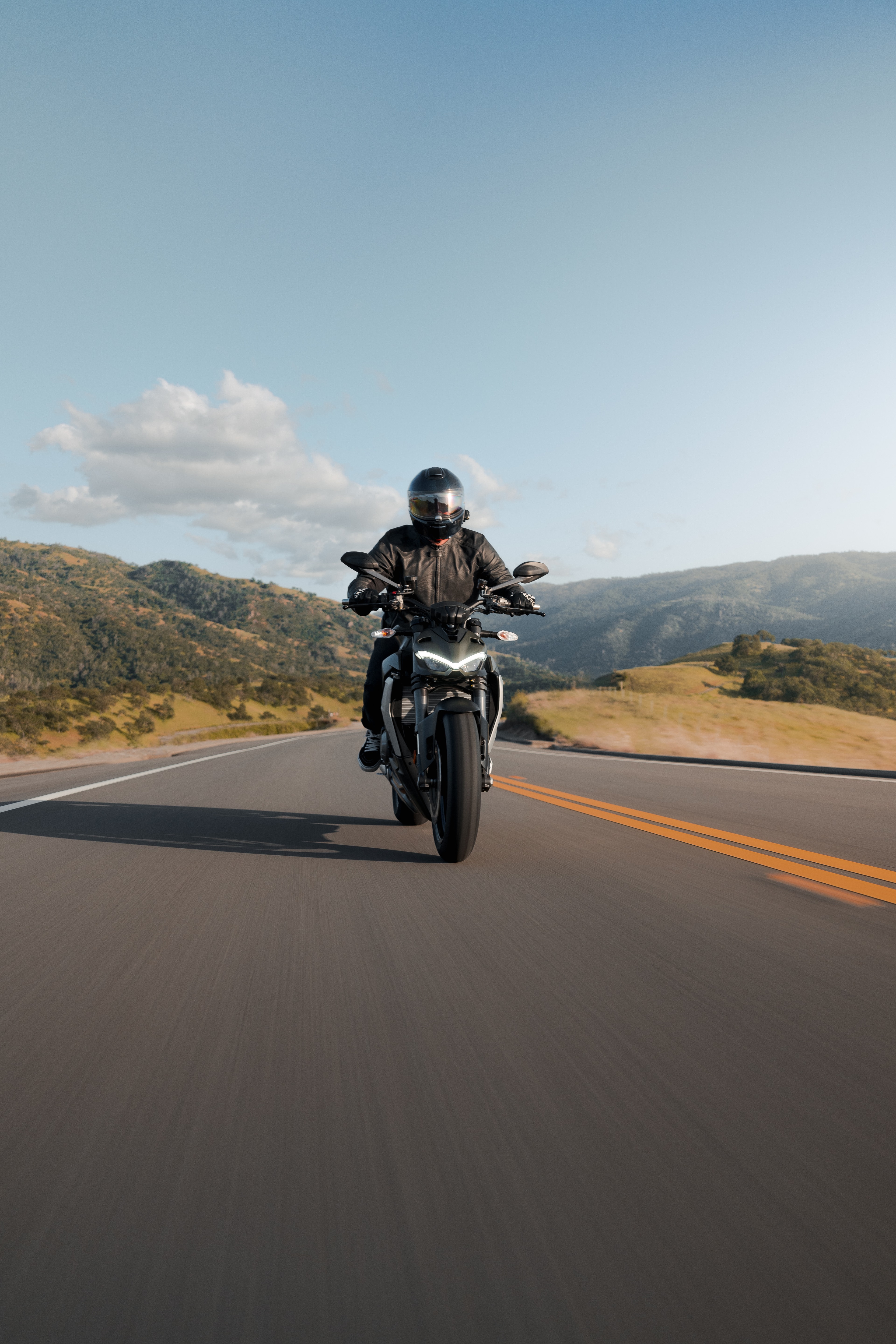 Solo Ducati Street Fighter rider front view, golden hour mountain road