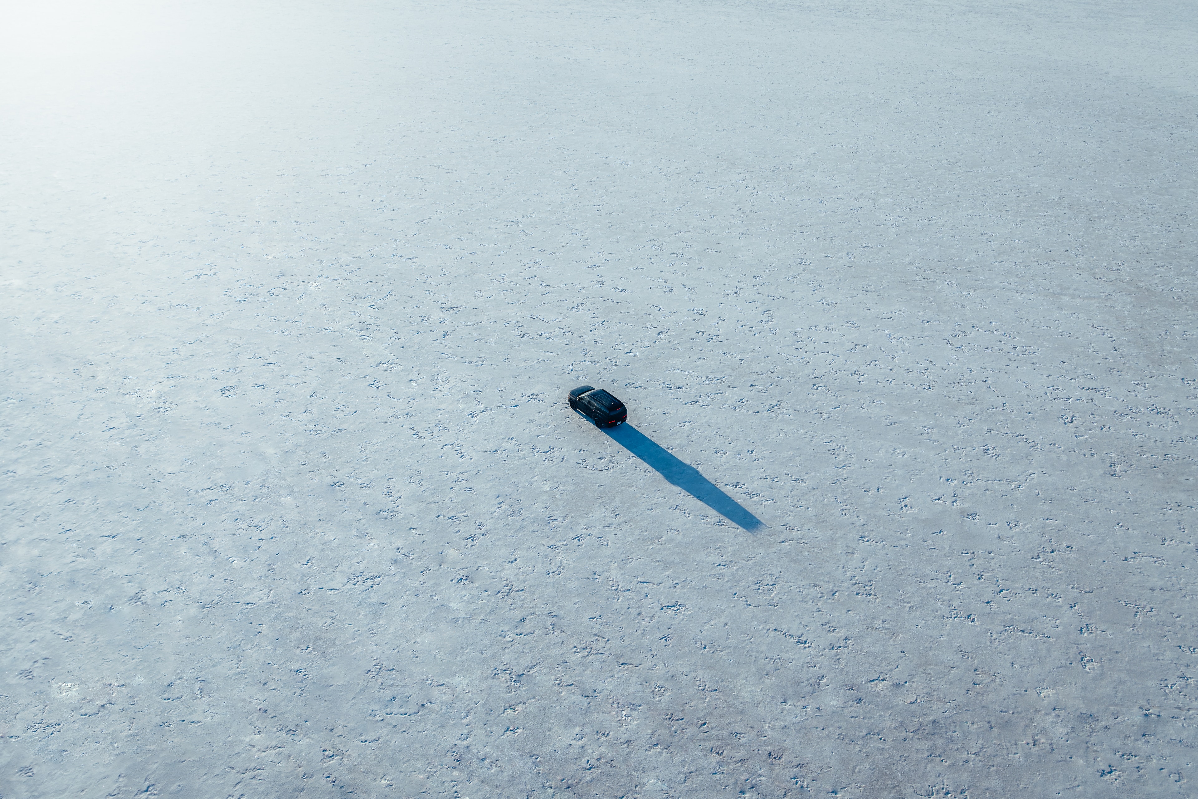 Aerial of the lone Santa Fe casting a long shadow across the white salt flats