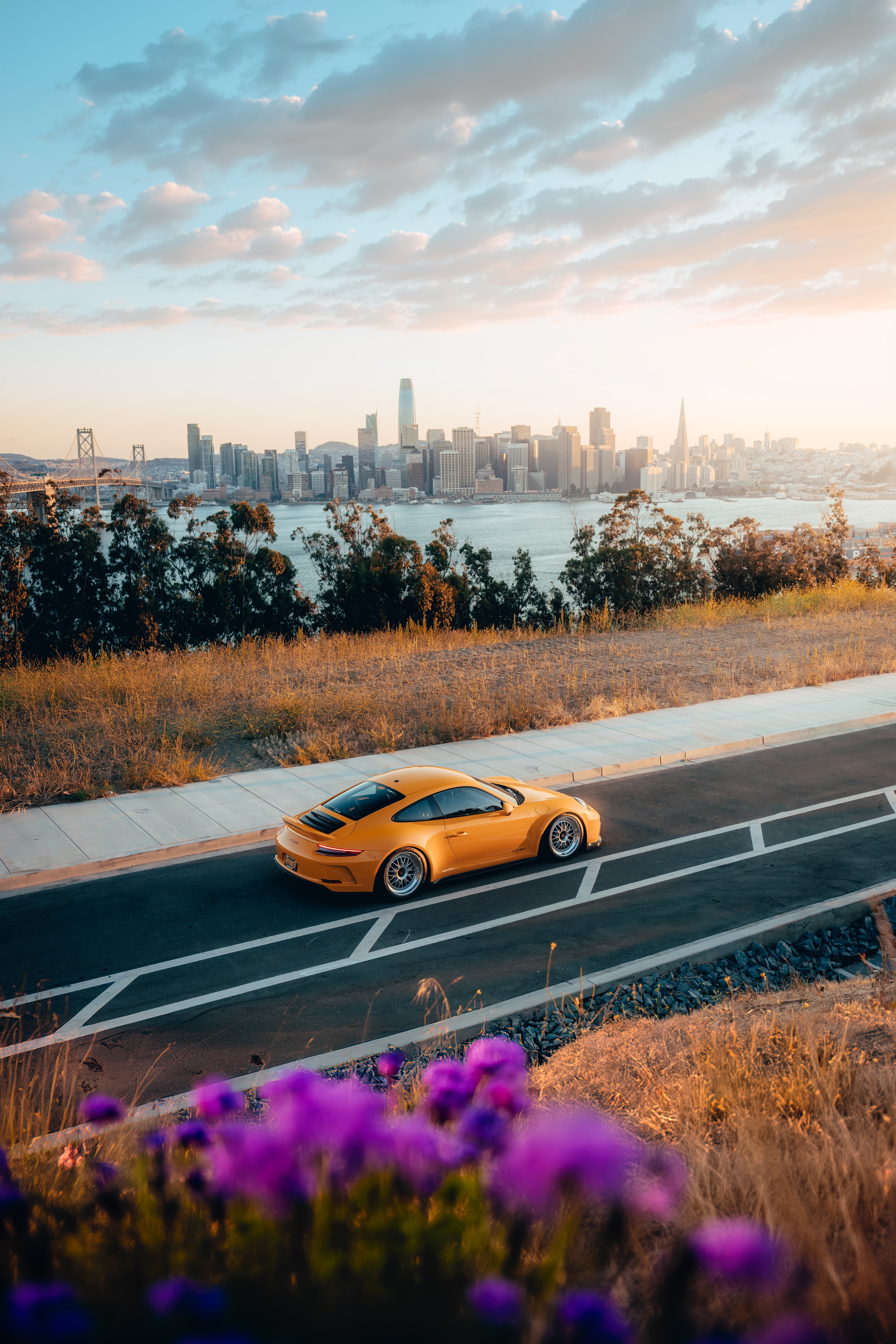 Yellow 911 GT3 at Treasure Island with SF skyline and Bay Bridge at sunset