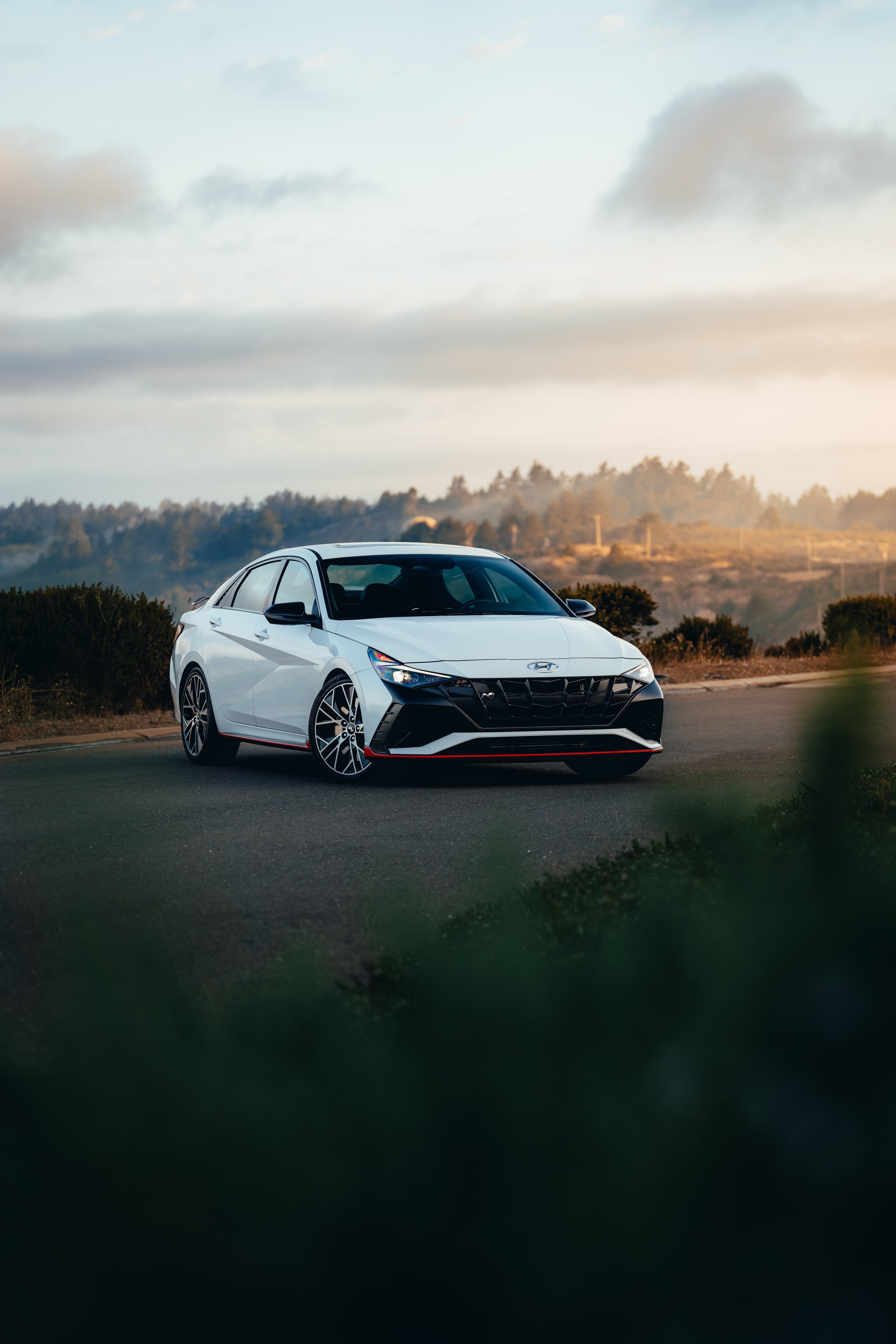 Hyundai Elantra N front three-quarter at a coastal overlook, foggy golden hills behind