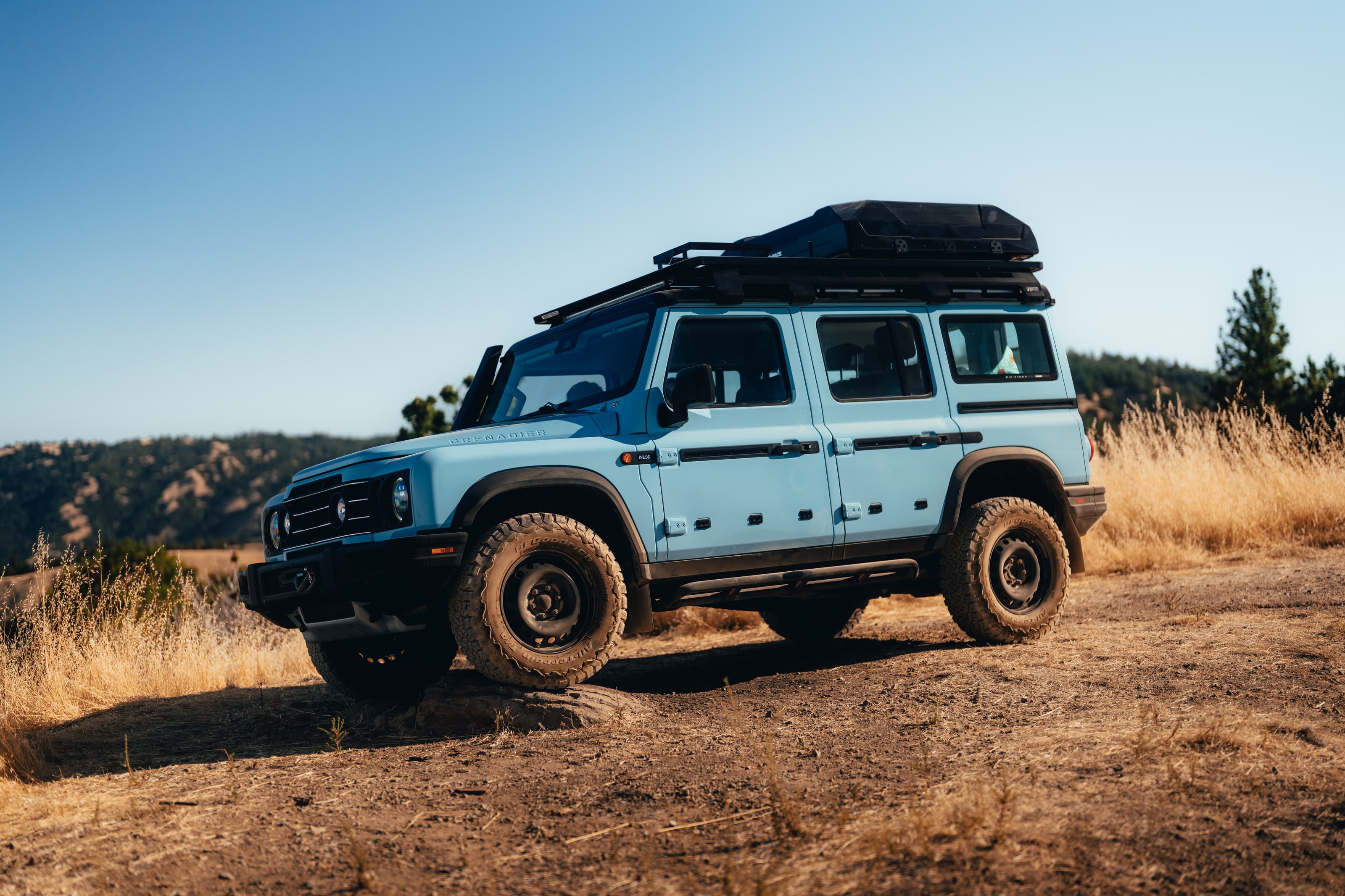 Light blue INEOS Grenadier side profile in golden California hills