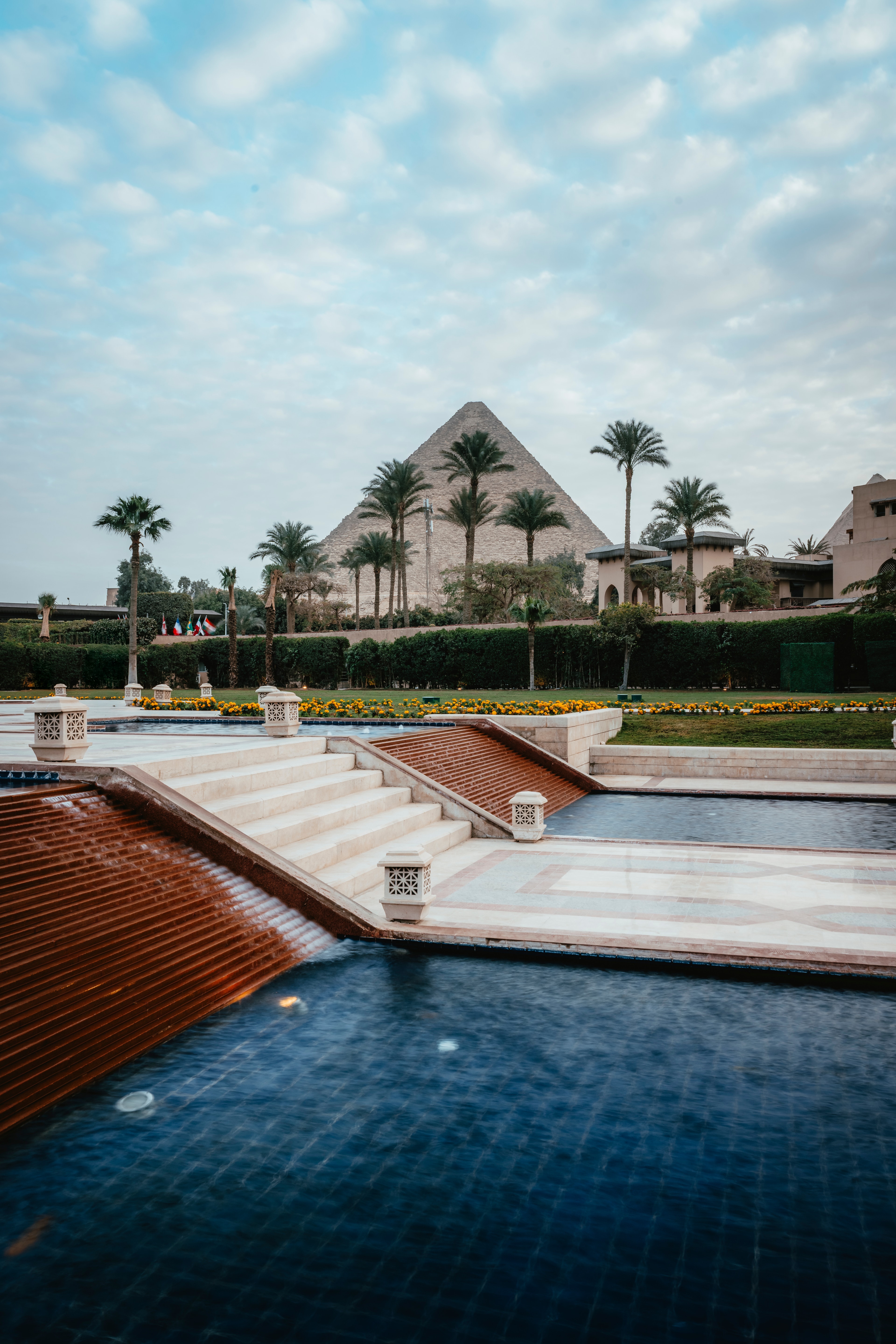 The Mena House pool with the Great Pyramid framed between palm trees
