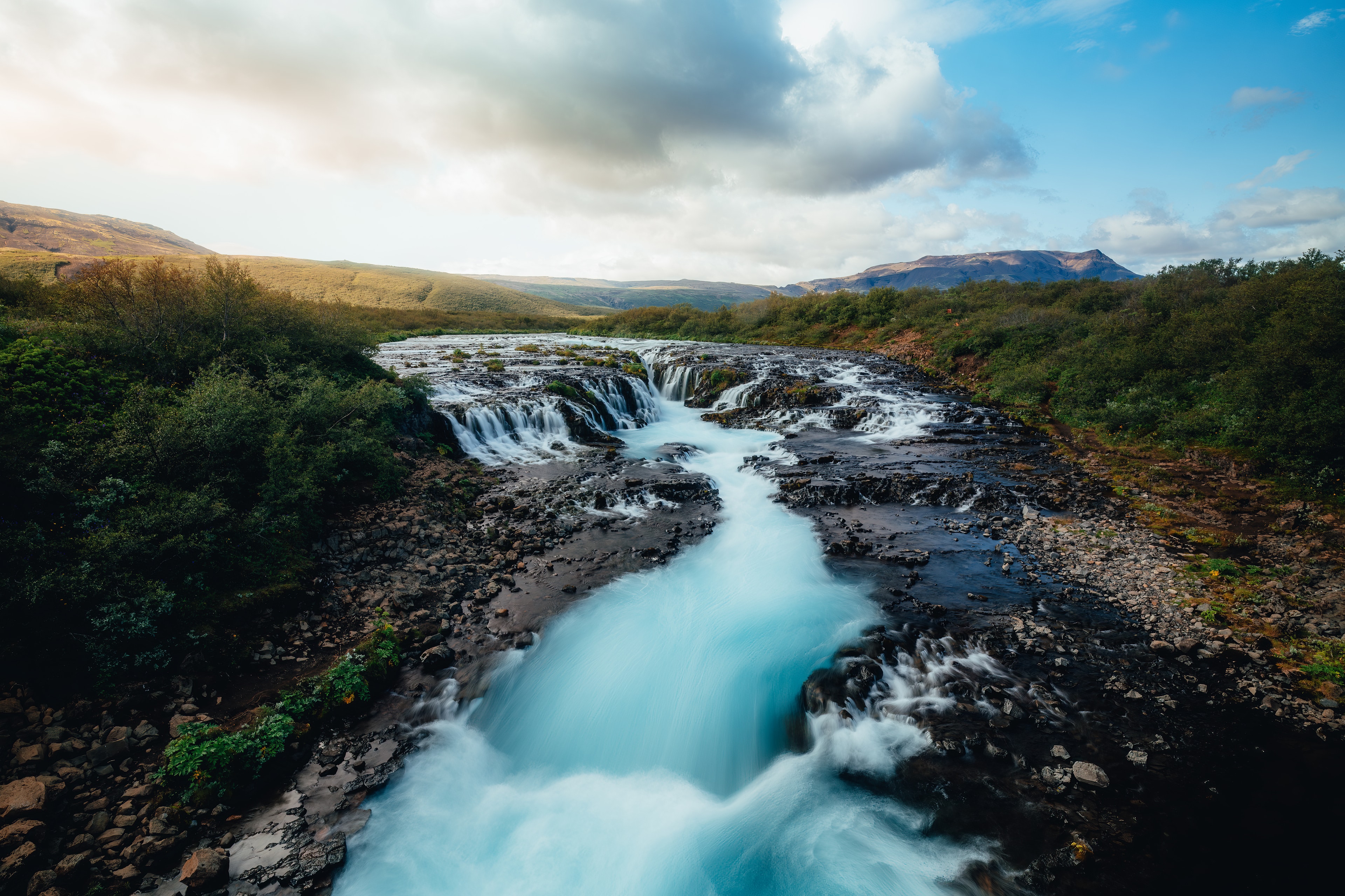 The braided turquoise cascade of Bruarfoss under a bright sky
