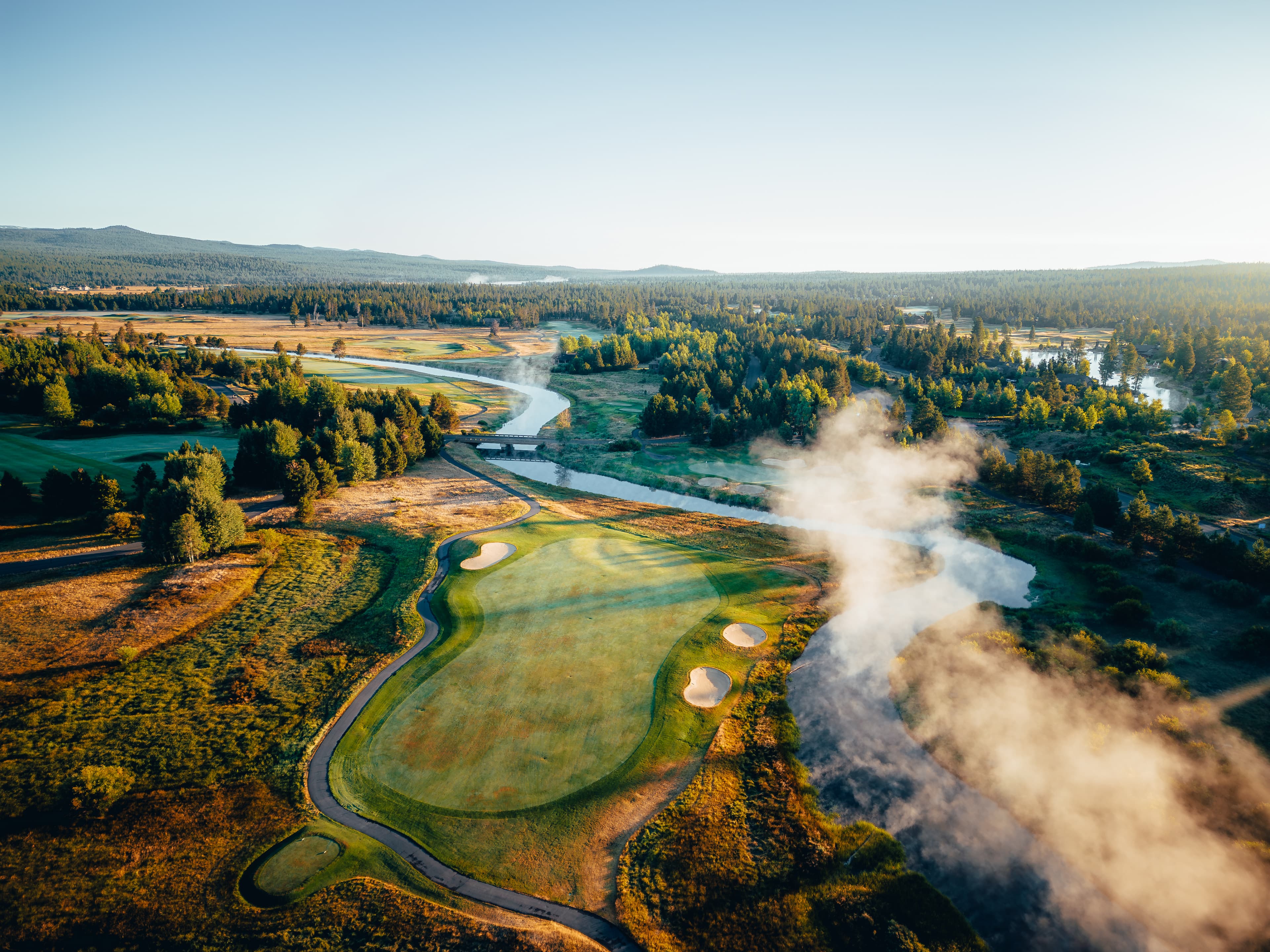 Morning steam rising off the river as it winds through the Crosswater course, aerial view