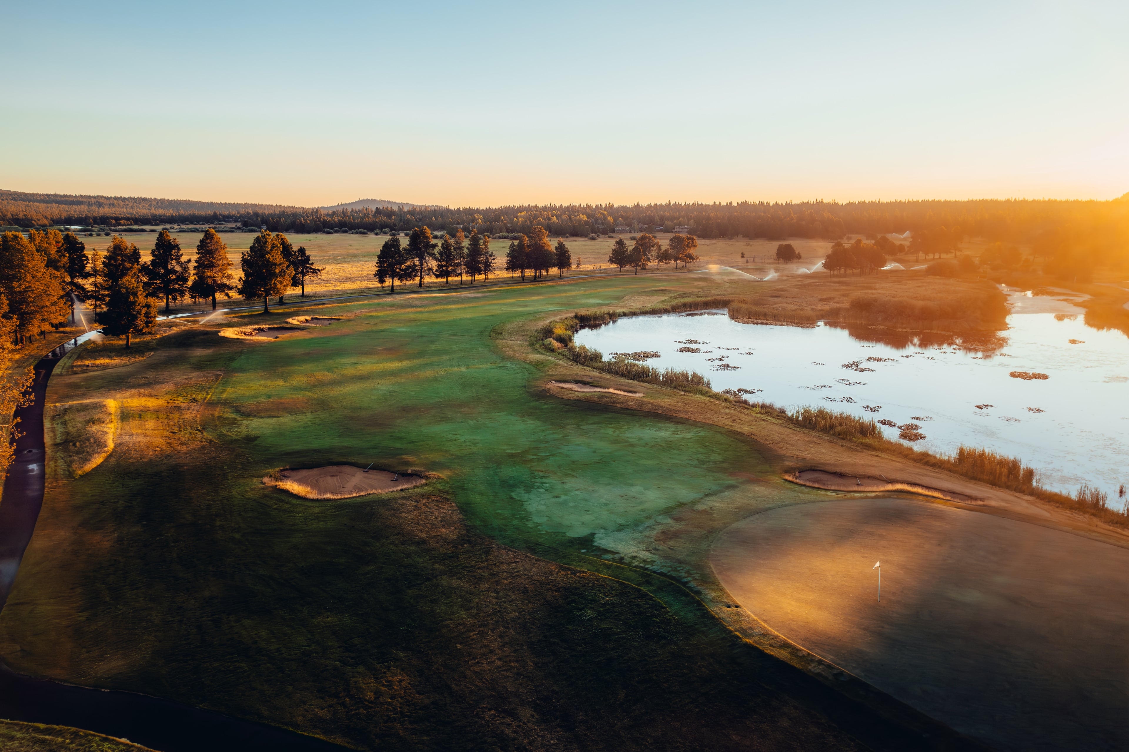 Sunset aerial over the marsh edges of the Meadows course