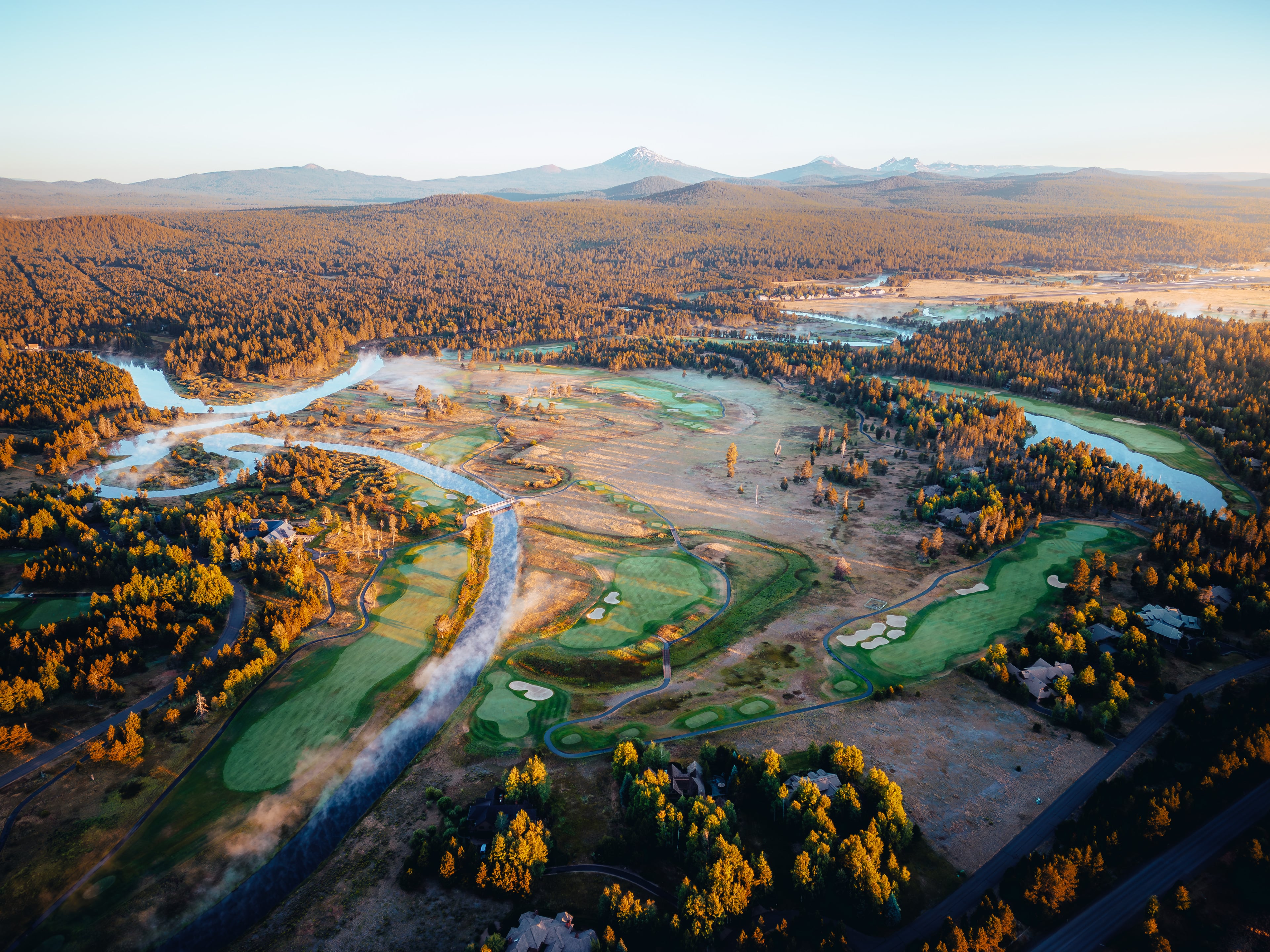 The braided river spread wide below the course, Cascades along the horizon