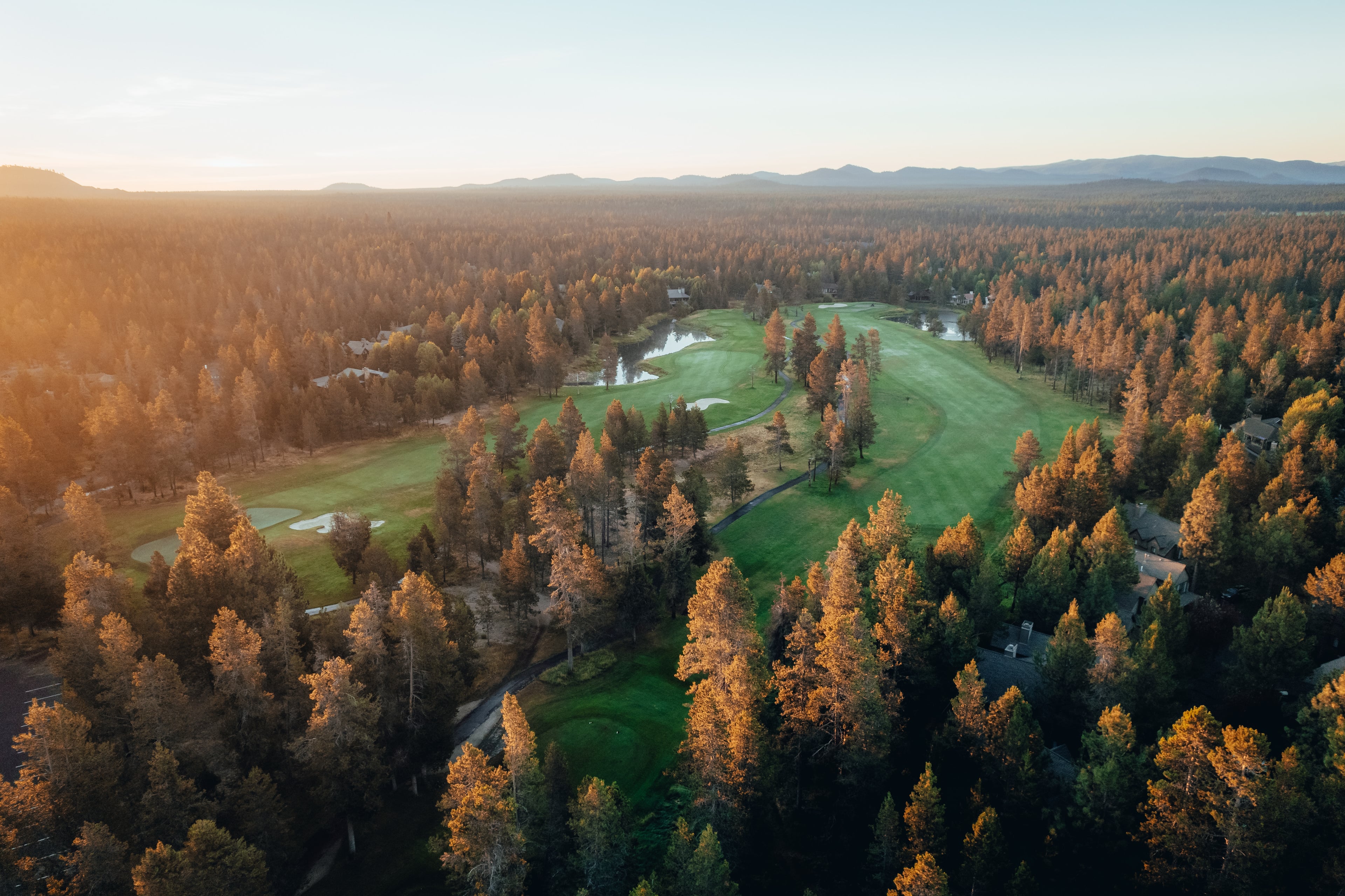 Sunset aerial over the Woodlands, the course cut through the pines